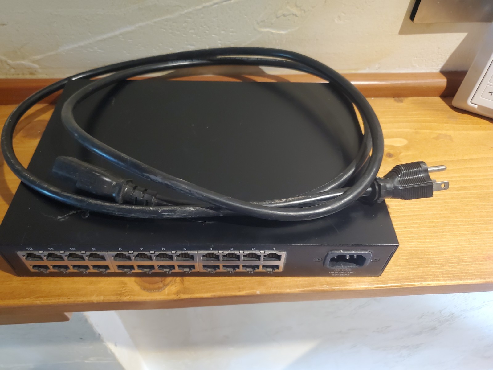 Pakedge SW24-GB 24-Port Gigabit Ethernet Switch with power cable.